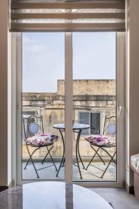 Habitación con vistas a un balcón con mesa y sillas. en Nocturnal Elegance Apartment by Solea, en Sliema