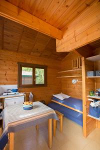 a log cabin with a table and a kitchen at Camping de Tauves in Tauves