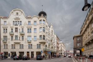 a large white building on a city street with cars at Best Place in Prague in Prague