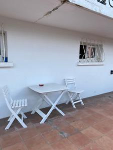 un tavolo e due sedie accanto a un muro bianco di home détente a Marmande