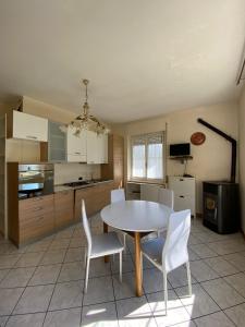 een keuken met een tafel en witte stoelen in een kamer bij Avventura e Relax a Bagnasco 1 in Bagnasco