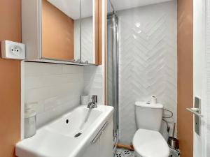 a white bathroom with a toilet and a sink at Le Petit Melun in Melun