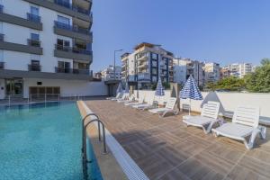 a row of chairs and a swimming pool on a building at Flat in Antalya