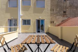 un banco de madera en el balcón de un edificio en Príncipe Apartamentos e Suites en Lisboa