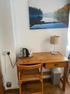 a wooden desk with a lamp and a chair at B Homestay in Maidstone