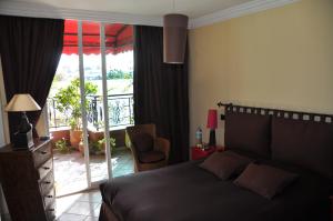 une chambre avec un lit et une porte coulissante en verre dans l'établissement Appartement agréable avec 2 très belles terrasses au coeur de Rabat, à Rabat