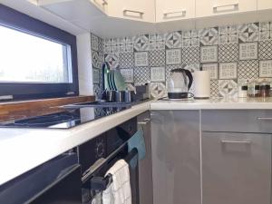 a kitchen with a stove top oven next to a window at Bocheniówka in Nowy Targ