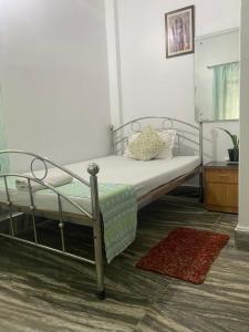 sypialnia z metalowym łóżkiem i dywanem w obiekcie Lasaya apartment w mieście Siliguri