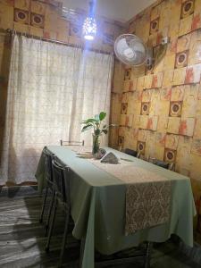 stół w pokoju z zieloną tkaniną w obiekcie Lasaya apartment w mieście Siliguri