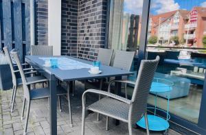 a blue table and chairs on a balcony at Marina 22-B in Cuxhaven