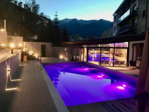 a swimming pool with purple lights on a building at Private Spa Luxury apartments in Bansko