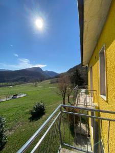 a balcony of a yellow house with a view of a field at Avventura e Relax a Bagnasco 2 in Bagnasco