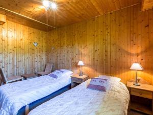 two beds in a room with wooden walls at Chalet La Clusaz, 4 pièces, 6 personnes - FR-1-437-33 in La Clusaz
