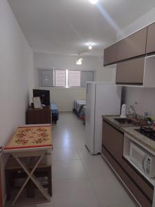 uma cozinha com uma mesa e um frigorífico em Apto com Garagem e Wi-Fi a 4 minutos da Canção Nova em Cachoeira Paulista