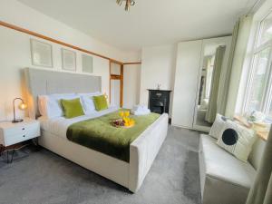 a bedroom with a large bed and a couch at Lovely 4-Bed House in Luton in Luton