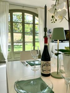 una botella de vino sentada en una mesa con copas en Just Langhe Casa Barolo, en Novello