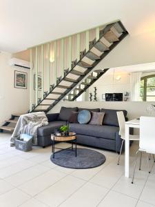 sala de estar con sofá y escalera en Just Langhe Casa Barolo, en Novello