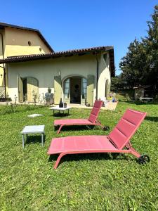dos sillas rosas y una mesa frente a una casa en Just Langhe Casa Barolo, en Novello