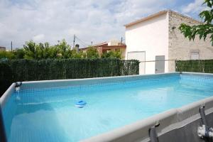 a large blue swimming pool in front of a building at 3 bedrooms house with private pool enclosed garden and wifi at Camarles 5 km away from the beach in Camarles