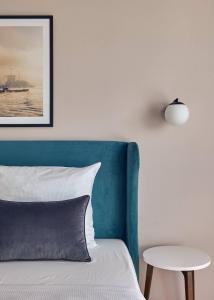 a bed with a blue headboard and a table at Makro Apartments in Hamburg