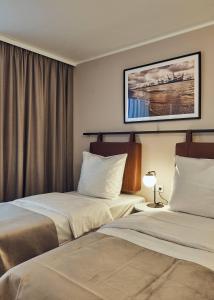 Habitación de hotel con 2 camas y una foto en la pared en Makro Apartments en Hamburgo