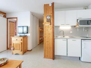 a small kitchen with white cabinets and a microwave at Appartement La Clusaz, 2 pièces, 4 personnes - FR-1-437-78 in La Clusaz