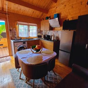 eine Küche mit einem Tisch und einer Obstschale darauf in der Unterkunft Chalet d'une chambre avec terrasse amenagee et wifi a L'Etang Sale in L’Étang-Salé