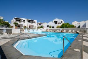 una gran piscina con casas blancas en el fondo en Casa Maesa, en Playa Honda
