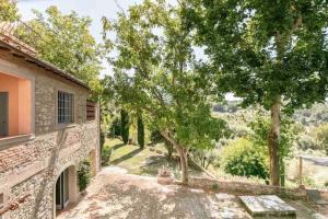 an external view of a house with trees in the yard at Isola del Pittore Fienile di Villa Storica in Grassina