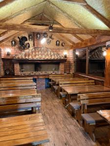 ein leeres Restaurant mit Holztischen und Bänken in der Unterkunft Kolasin - Hunting home in old village in Kolašin