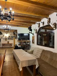 a living room with a couch and a tv at Kolasin - Hunting home in old village in Kolašin