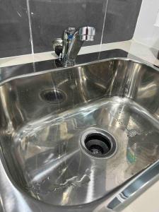a stainless steel sink with a faucet in a kitchen at P3 Great value, cozy, convenient in city! in Kuching
