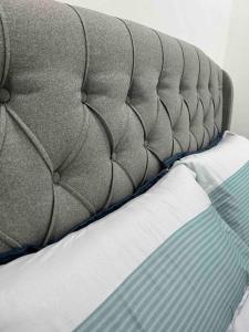 un primer plano de una cama con un cabecero gris en P3 Great value, cozy, convenient in city!, en Kuching