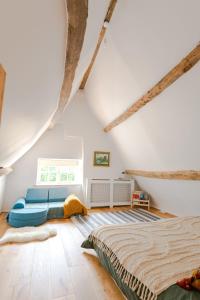a bedroom with a bed and a couch at Beautiful 3BD Thatched Stone Cottage Kettering in Pytchley
