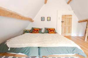 a bedroom with a large bed in a attic at Beautiful 3BD Thatched Stone Cottage Kettering in Pytchley