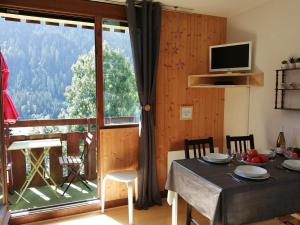 ein Esszimmer mit einem Tisch und einem großen Fenster in der Unterkunft Studio confortable à Châtel - 4 pers, balcon, parking et WiFi - FR-1-198-237 in Châtel