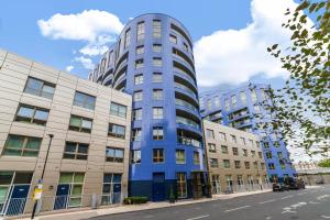 um edifício azul no meio de dois edifícios em Bright & Cozy 1 BDR Apt wCharming Private Terrace em Londres