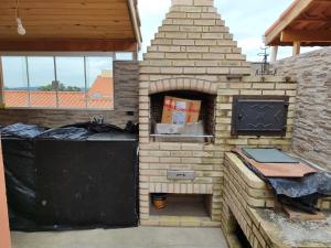 a brick oven with a grill in a patio at Aconchego in Mairinque