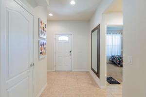 a hallway with a white door and a mirror at Cozy 5 Bed, wonderful clubhouse, Close to Disney in Kissimmee