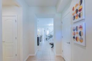 a hallway with white walls and a tile floor at Cozy 5 Bed, wonderful clubhouse, Close to Disney in Kissimmee