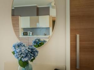a bathroom with a mirror and a vase with blue flowers at Residence Art in Rimini