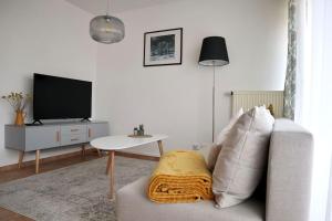 uma sala de estar com um sofá e uma televisão em Ferienwohnung Piendl em Münsingen