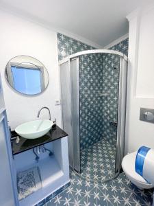 een badkamer met een wastafel en een douche bij Mercan Otel in Canakkale
