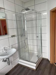 a bathroom with a glass shower and a sink at Eventhaus in Panzweiler