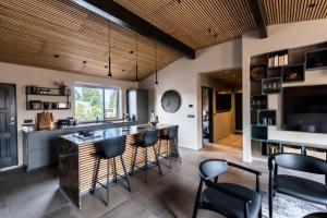 a kitchen with a bar with black stools at Private house in the center of Akureyri 