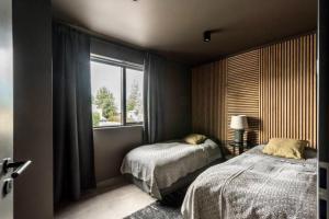 a bedroom with two beds and a large window at Private house in the center of Akureyri 