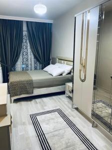 1 dormitorio con 1 cama con cortinas azules en 2+1 Luxury Flat , 5 beds , near all services en Esenyurt