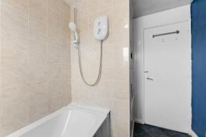 Das Bad ist mit einer Dusche und einer Badewanne ausgestattet. in der Unterkunft Sleek and Stylish 3 Bed House - Great Location in Bolton