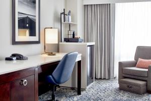 ein Hotelzimmer mit einem Schreibtisch und einem Stuhl in der Unterkunft Sheraton Indianapolis Hotel at Keystone Crossing in Indianapolis