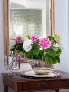 a vase filled with pink and white flowers on a table at Hotel Acapulco in Milano Marittima